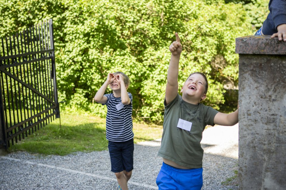 Rõõmsad lapsed jooksevad Tartu tähetorni väravast sisse.