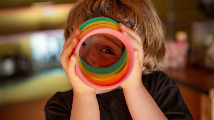 Laps vaatab läbi värvilise vedru.