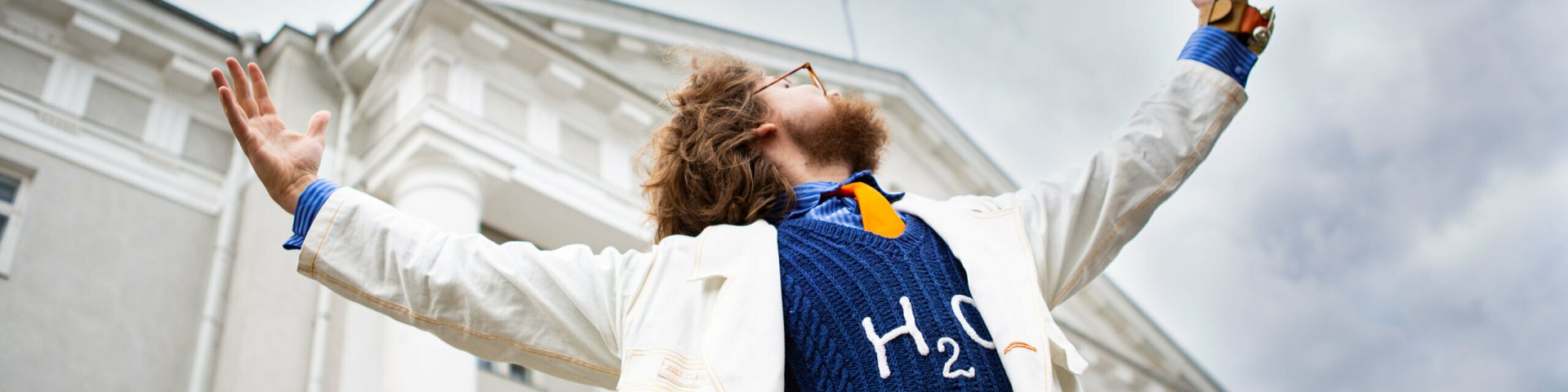 Hull Teadlane Tartu Ülikooli peahoone ees käsi õhku laiutamas.